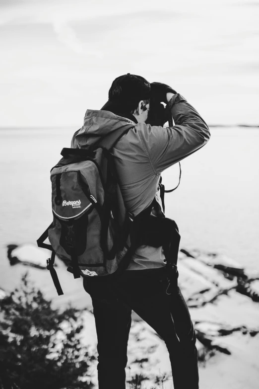 a black and white photo of a man with a backpack, by Anton Lehmden, unsplash contest winner, taking a picture, eyelevel!!! view!!! photography, ✨🕌🌙