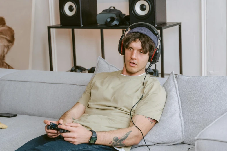 a man sitting on a couch with headphones on, pexels, hyperrealism, gaming room, nathan fielder, joe keery, instagram picture