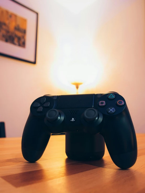 a video game controller sitting on top of a wooden table, a cartoon, unsplash, on a candle holder, low quality photo, taken with sony alpha 9, instagram picture