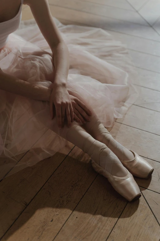 a woman in a white dress is sitting on the floor, by Elizabeth Polunin, unsplash contest winner, arabesque, shows a leg, wearing a pink tutu, silver，ivory, heartbreak