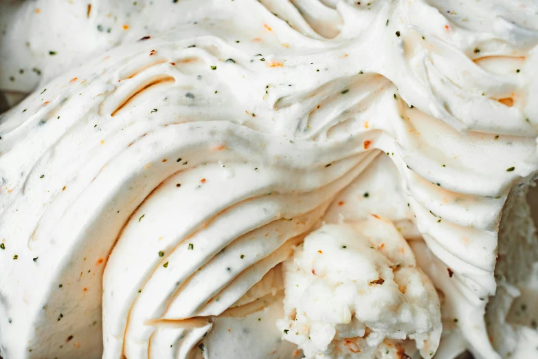 a close up of a cake with white frosting, by Carey Morris, savory, lots of swirling, promo image, ice cream