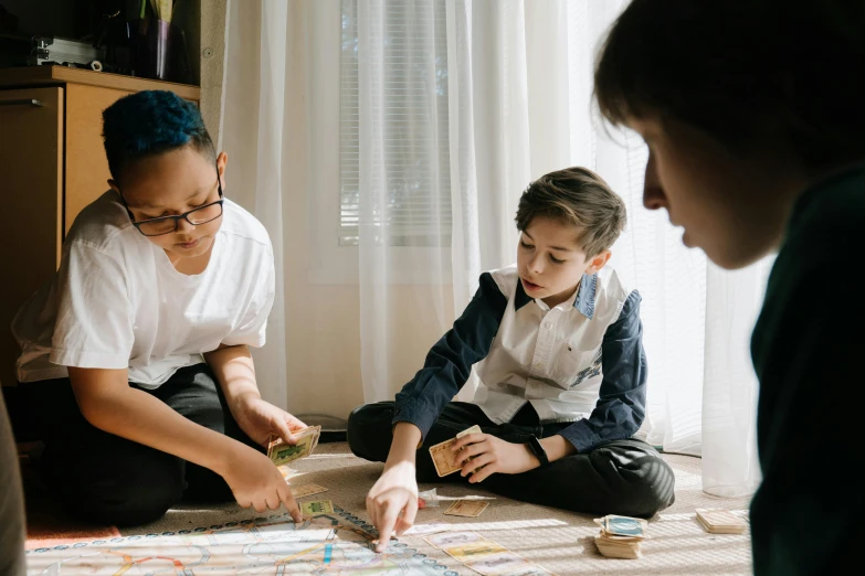 a group of people sitting on the floor playing a game, a child's drawing, by Kristian Zahrtmann, pexels contest winner, game board, looking across the shoulder, gif, husband wife and son