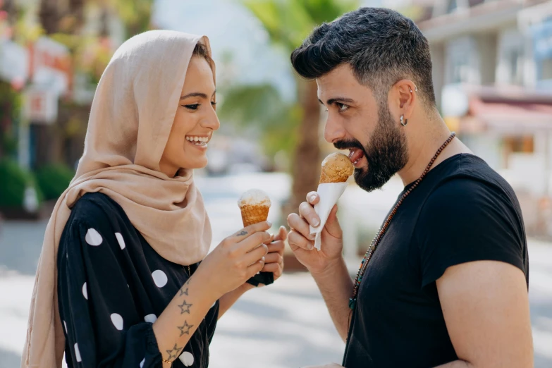 a man and woman sharing an ice cream cone, a photo, trending on pexels, hurufiyya, wearing a head scarf, handsome man, with a long, middle eastern