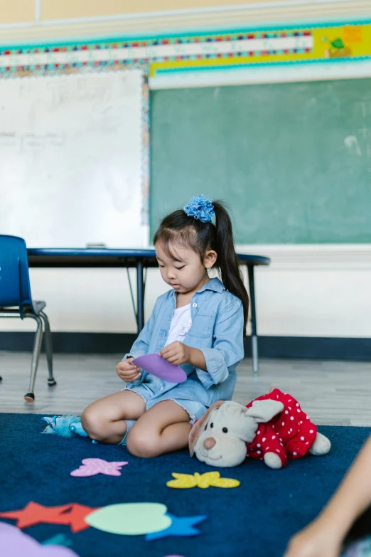 a group of children sitting on the floor in a classroom, by Greg Spalenka, pexels contest winner, process art, young asian girl, toy commercial photo, sitting alone, katelynn mini cute style