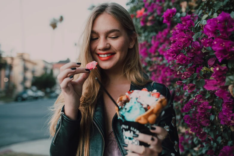 a woman in a leather jacket eating an ice cream sundae, by Julia Pishtar, trending on pexels, girl in flowers, pink and blue neon, people outside eating meals, sweet smile