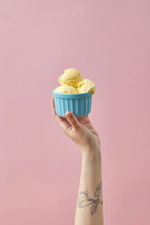 a person holding a bowl of ice cream, blue and yellow