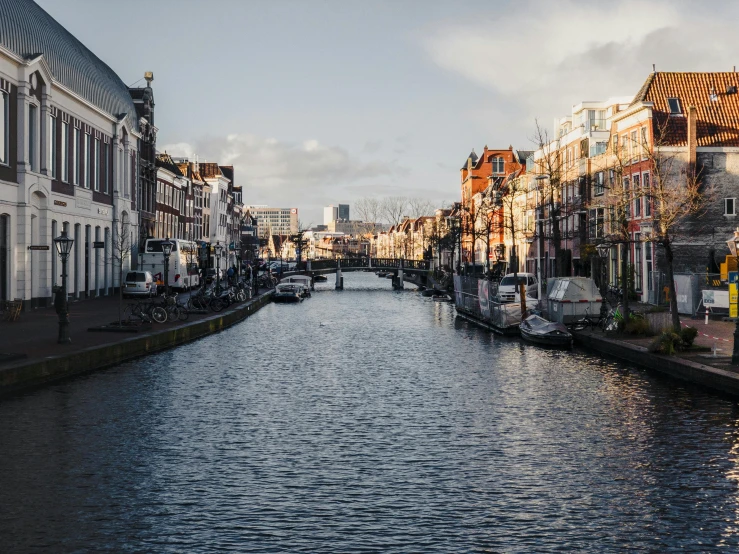 a river running through a city next to tall buildings, by Jan Tengnagel, pexels contest winner, renaissance, delft, nice afternoon lighting, thumbnail, slightly pixelated