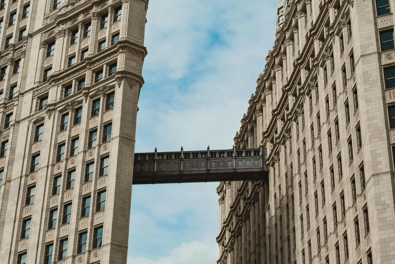 a couple of tall buildings sitting next to each other, by Nick Fudge, pexels contest winner, surrealism, sky bridge, with stalinist style highrise, 1910s architecture, broadway