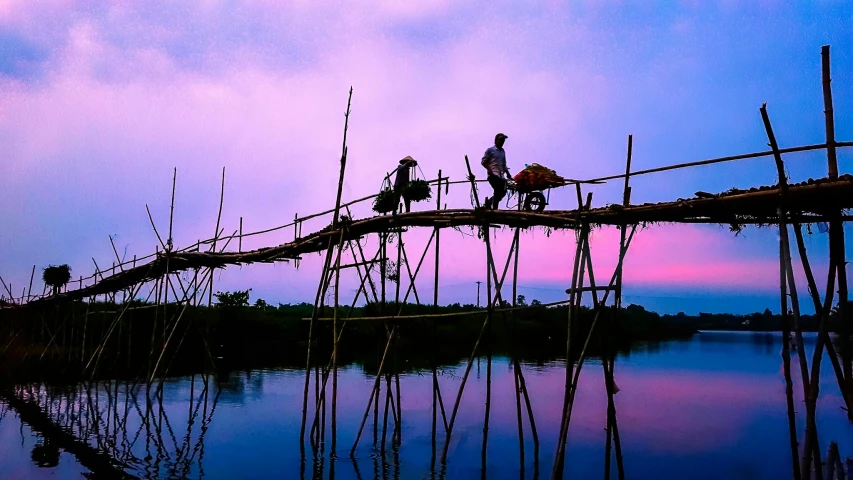 a group of people standing on top of a wooden bridge, by Sudip Roy, pexels contest winner, purple and pink, fishing town, vine bridge silhouette over lake, slide show