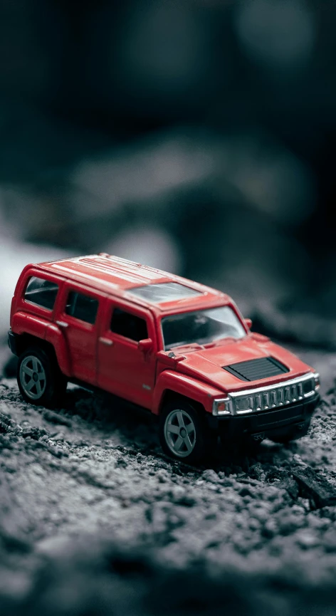 a red toy car sitting on top of a rock, a tilt shift photo, pexels contest winner, photorealism, future jeep concept suv, thumbnail, sports car in the room, high resolution image