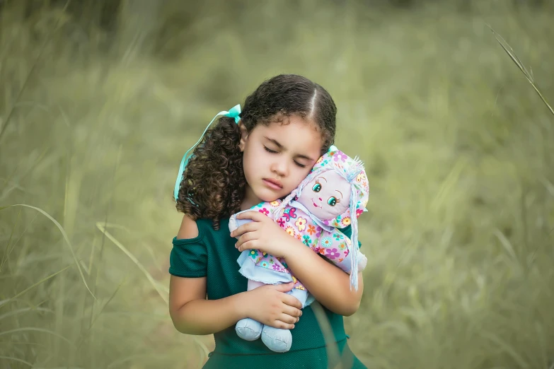 a little girl holding a stuffed animal in a field, by Lilia Alvarado, pexels, sad face, multicoloured, various posed, portrait young girl