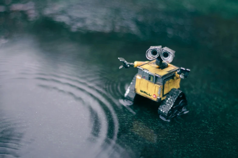 a close up of a toy truck in a body of water, inspired by Pixar, pexels contest winner, standing in the rain, cute robot, despicable, introspective