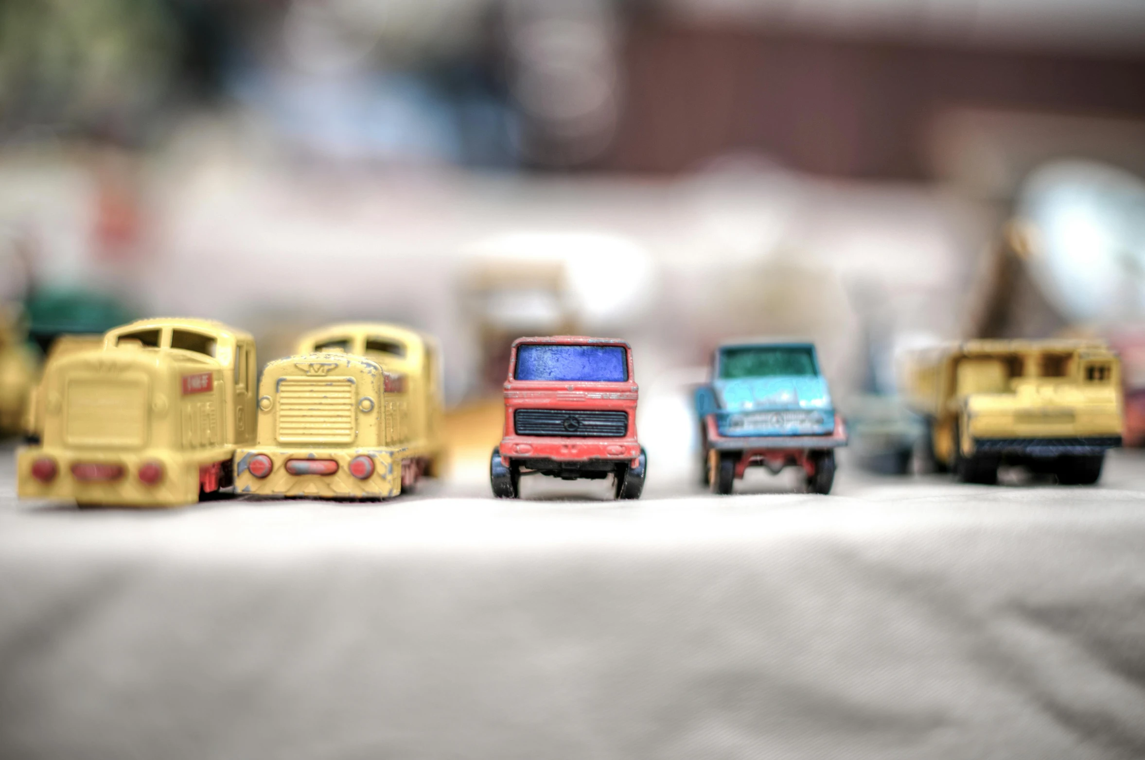 a group of toy cars sitting on top of a table, unsplash, photorealism, trucks, vintage photo, multiple stories, unblur