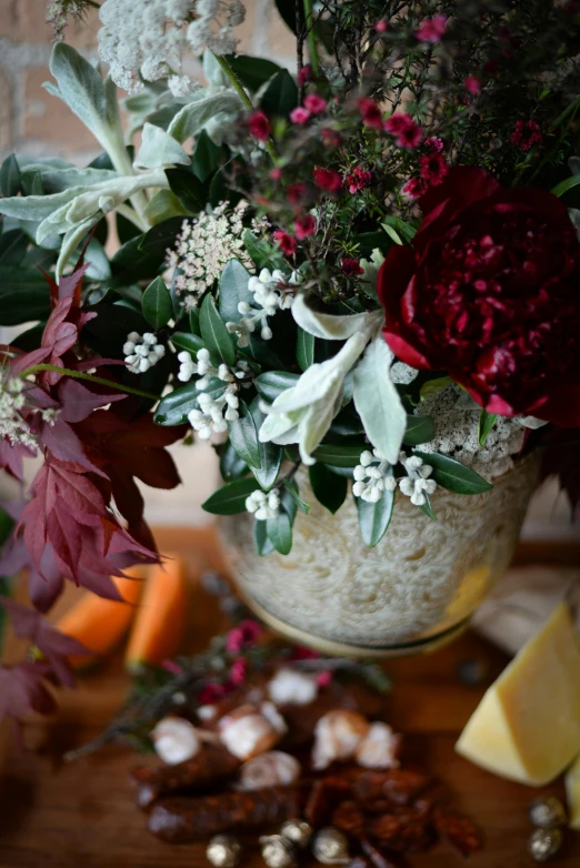 a vase of flowers sitting on top of a wooden table, festive atmosphere, vibrant foliage, up-close