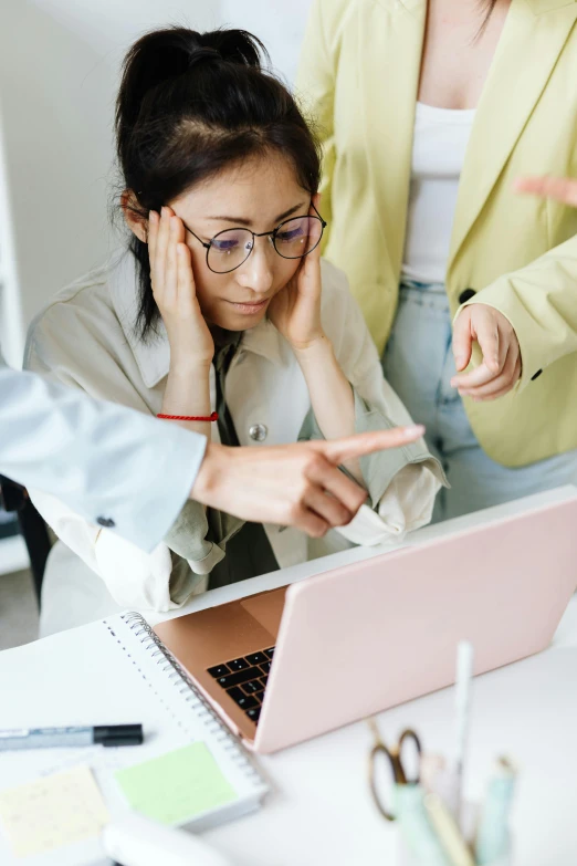 a couple of women sitting at a table with a laptop, pexels, hypermodernism, frustrated expression, an asian woman, in an office, thumbnail