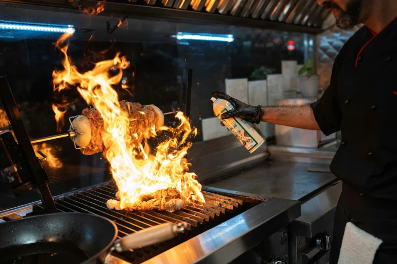 a man that is cooking some food on a grill, holding a torch, chefs table, te pae, profile image