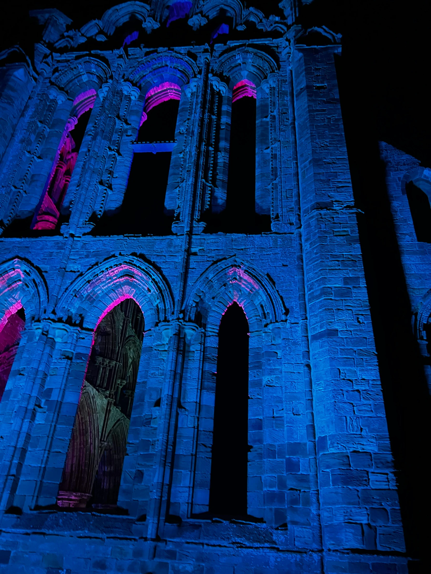 a very tall building with a clock on it's side, an album cover, by Ben Thompson, pexels contest winner, romanesque, glowing blue veins, concert photo, fuchsia and blue, english heritage