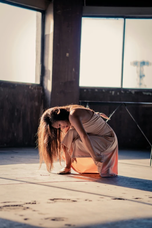 a woman bending over in an empty room, by Elizabeth Polunin, unsplash, happening, girl sitting on a rooftop, with a hurt expression, in the sun, performance art