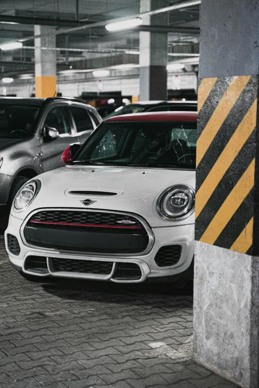 a row of cars parked in a parking garage, pexels contest winner, red mini cooper s, white and red body armor, inspect in inventory image, front of car angle