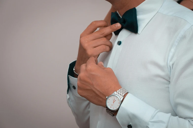 a man wearing a white shirt and a black bow tie, trending on pexels, wearing a watch, white and teal garment, animation, platinum jewellery