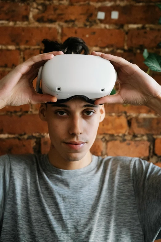 a man wearing a virtual reality headset in front of a brick wall, trending on pexels, renaissance, goggles on forehead, male teenager, technoviking male with no shirt, white helmet