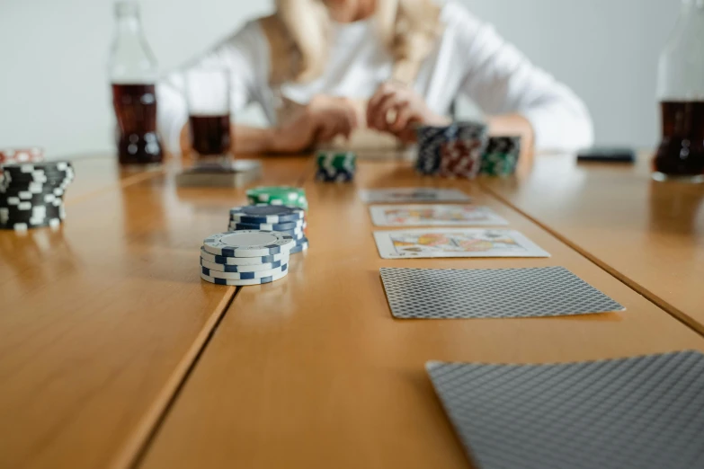 women at table, with three decks of poker cards and two beer glasses