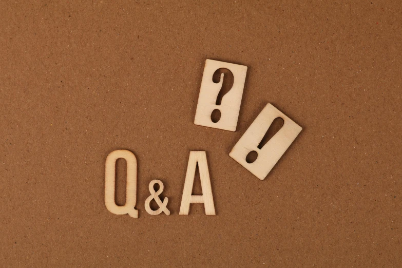 a wooden block with question and a question mark on it, by Emma Andijewska, unsplash, three quater notes, in a shapes background, letter a, beige