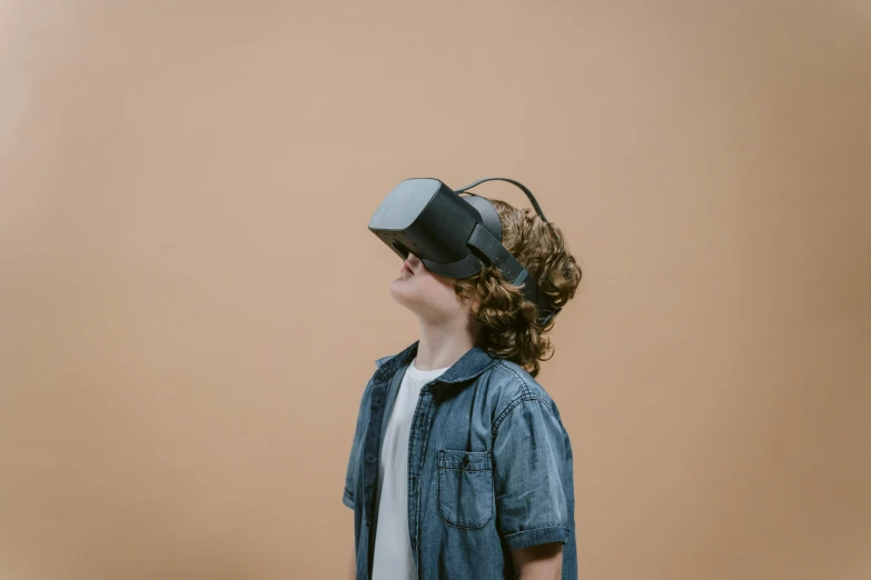 a young boy wearing a virtual reality headset, by Carey Morris, trending on unsplash, interactive art, on a gray background, trending on dezeen, taken in the early 2020s, rpg item