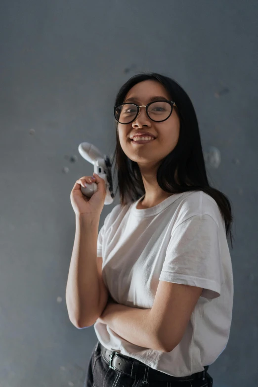 a woman holding a hair dryer in her hand, inspired by Feng Zhu, pexels contest winner, happening, portrait of teenage girl, holding scimitar made of bone, engineer, an all white human