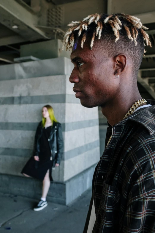 a man with dreadlocks standing in a parking garage, trending on unsplash, visual art, non binary model, on the runway, two people, black teenage boy