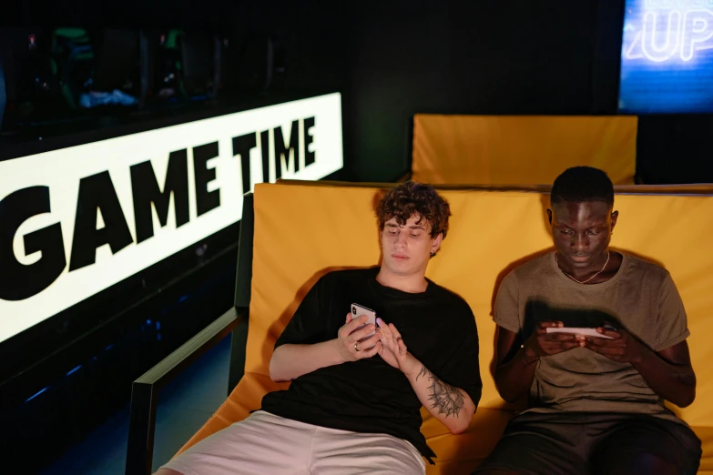 a couple of men sitting next to each other on a couch, pexels, graffiti, neon letters tripmachine, game hud, declan mckenna, time