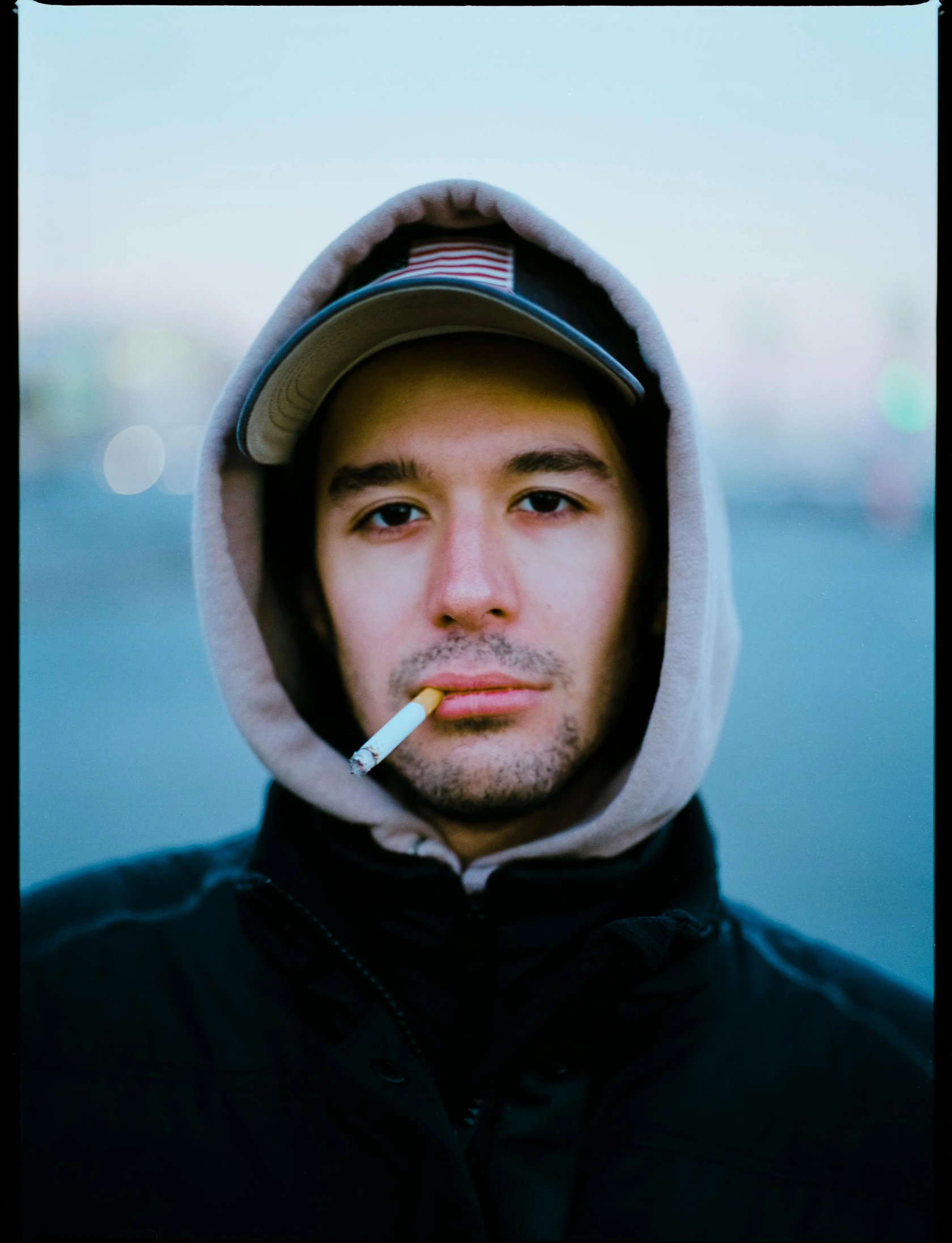 a man with a cigarette in his mouth, a polaroid photo, inspired by Liam Wong, unsplash, realism, discord pfp, hat and hoodie, discord profile picture, mark edward fischbach