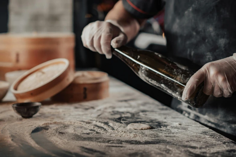 a close up of a person holding a bottle of wine, pexels contest winner, process art, bakery, working in the forge, chinese, holding a baguette