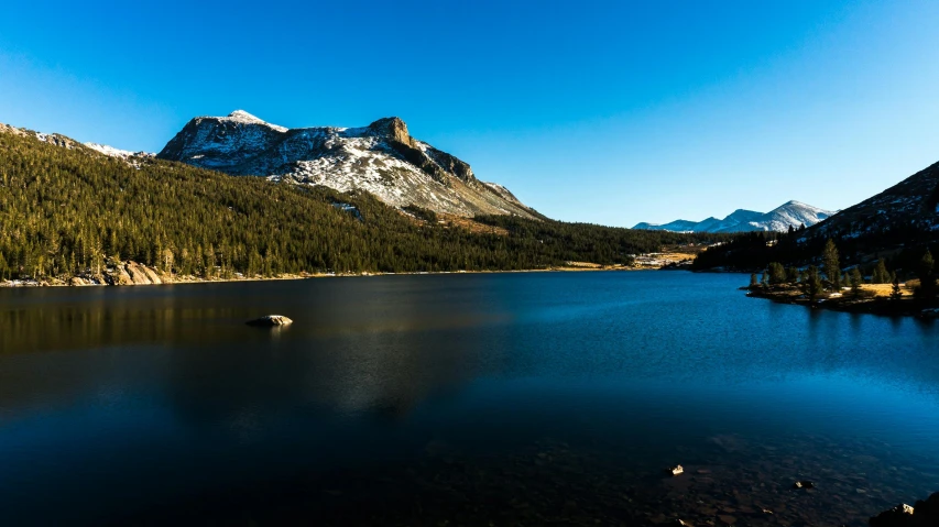 a large body of water surrounded by mountains, a photo, unsplash, hurufiyya, mammoth, clear blue skies, 2000s photo, beautiful late afternoon