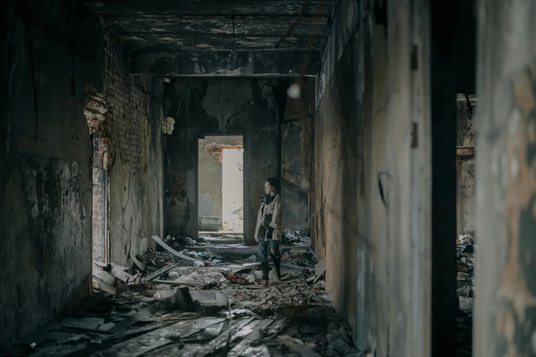 a man standing in the middle of a run down building, destruction around her, cinematic image, in a room, burnt