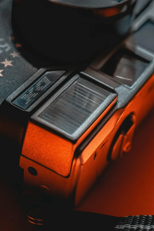 a close up of a camera on a table, orange tint, hyperdetailed photo, fujifilm x - pro 2, low - angle shot