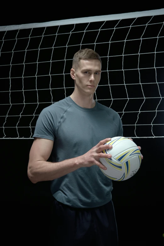 a man holding a soccer ball in front of a net, andrea savchenko, very tall and slender, commercial shot, scott adams