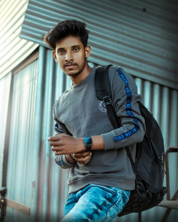 a man with a backpack looking at his cell phone, inspired by Max Dauthendey, pexels contest winner, graffiti, indian super model, wearing sweatshirt, looking straight to camera, discord profile picture