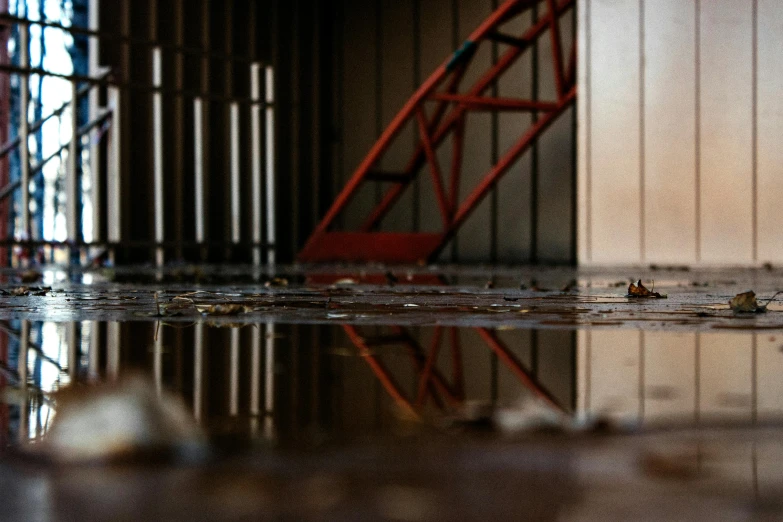 a red fire hydrant sitting on top of a puddle of water, a picture, inspired by Elsa Bleda, pexels contest winner, inside a warehouse, inside a brutalist space ship, water reflection on the floor, hangar