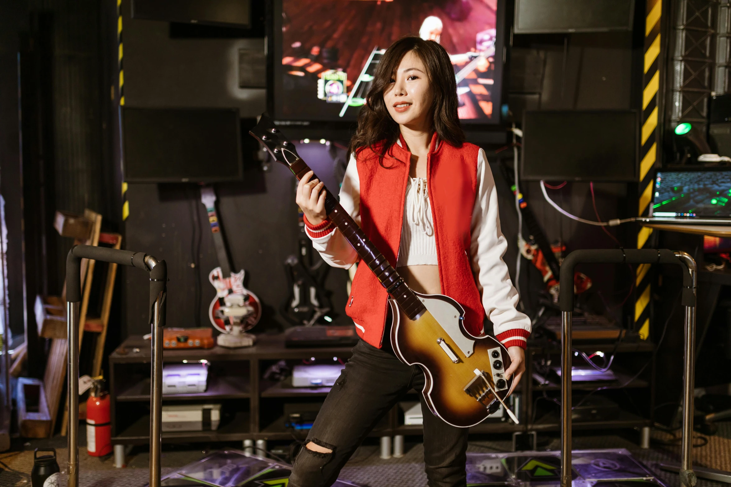 a woman standing in a room holding a guitar, inspired by Song Maojin, wearing cyberpunk 2 0 7 7 jacket, tzuyu from twice, double bass, fujifilm”