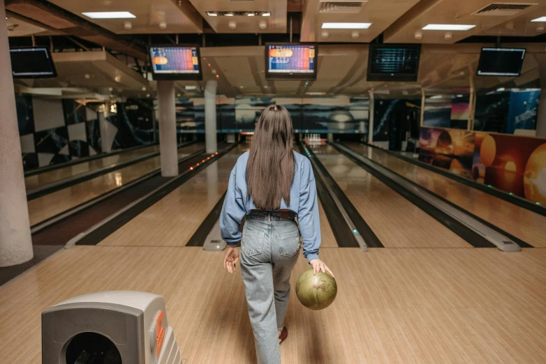 a woman walking down a bowling alley holding a bowling ball, by Julia Pishtar, unsplash contest winner, long hair, in full growth from the back, 15081959 21121991 01012000 4k, sydney hanson