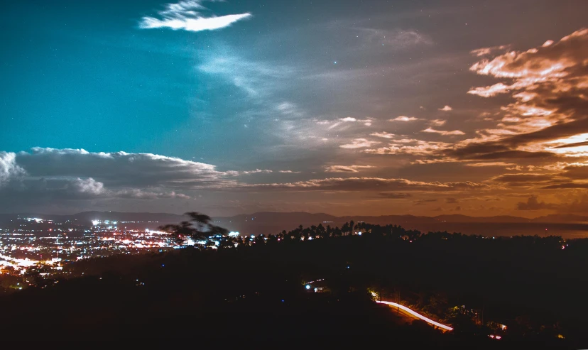 a view of a city at night from a hill, pexels contest winner, hurufiyya, ☁🌪🌙👩🏾, orange and cyan lighting, mulholland drive, sun down