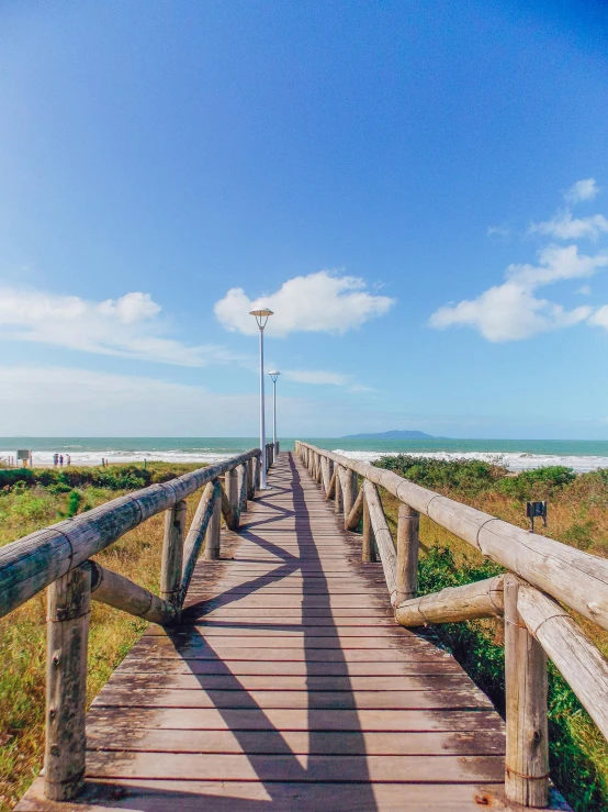 a wooden walkway leading to the beach, by Niko Henrichon, unsplash, farol da barra, 2 5 6 x 2 5 6 pixels, 4k panoramic, looking towards camera