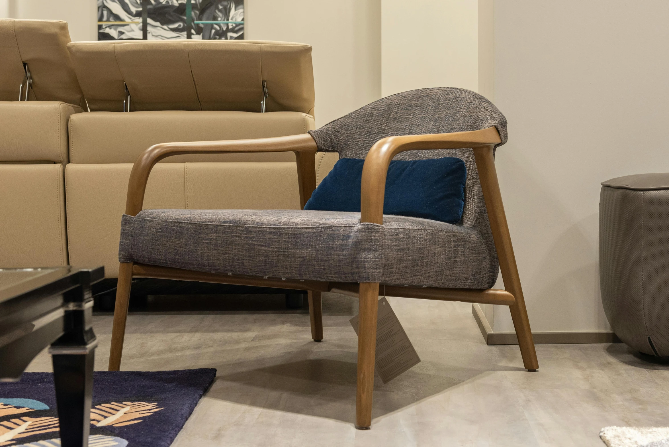 a chair sitting in a living room next to a couch, inspired by Emilio Grau Sala, mingei, premium quality, wood effect, taupe, indigo