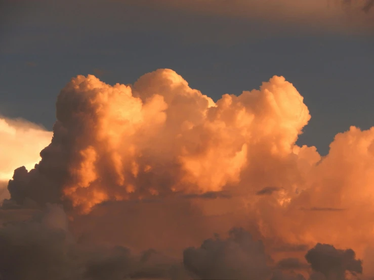 a bunch of clouds that are in the sky, an album cover, by Jessie Algie, unsplash, romanticism, orange glow, giant cumulonimbus cloud, late afternoon light, taken in the late 2010s