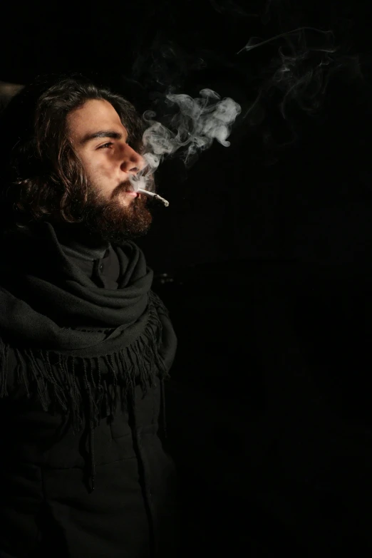 a man smoking a cigarette in the dark, by Pablo Rey, cannabis, with a beard and a black shirt, shabab alizadeh, man wearing a closed cowl