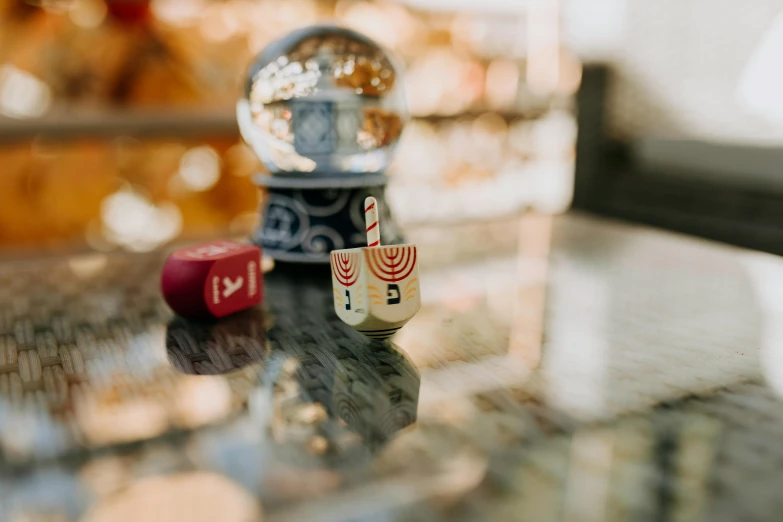 a couple of dice sitting on top of a table, a tilt shift photo, by Julia Pishtar, unsplash contest winner, magical realism, shrines, shot on iphone 1 3 pro max, still of rainbow ophanim, decorated ornaments
