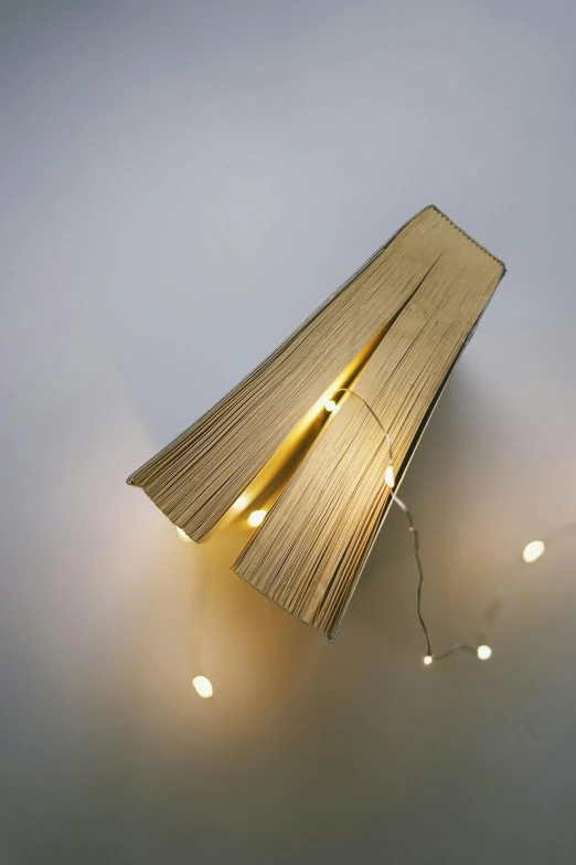 a close up of a light on a wall, by David Donaldson, conceptual art, big open book, string lights, top down view, gold light