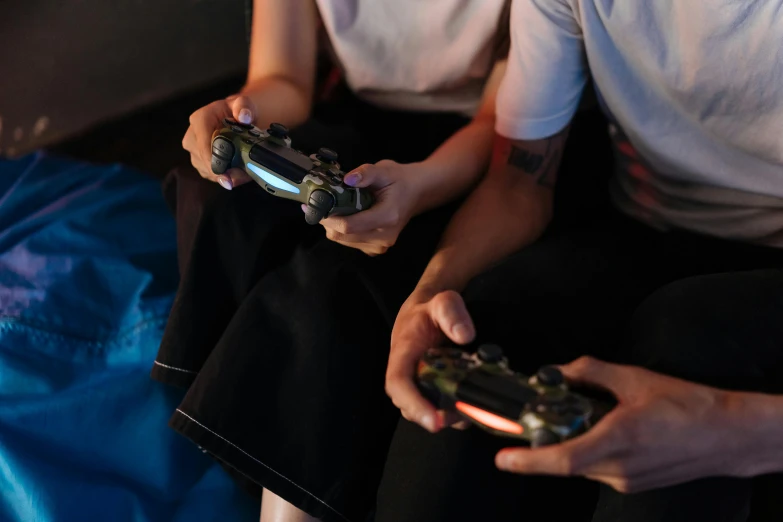 two people sitting on a couch playing a video game, pexels, closeup of arms, avatar image, bisexual lighting, playstation