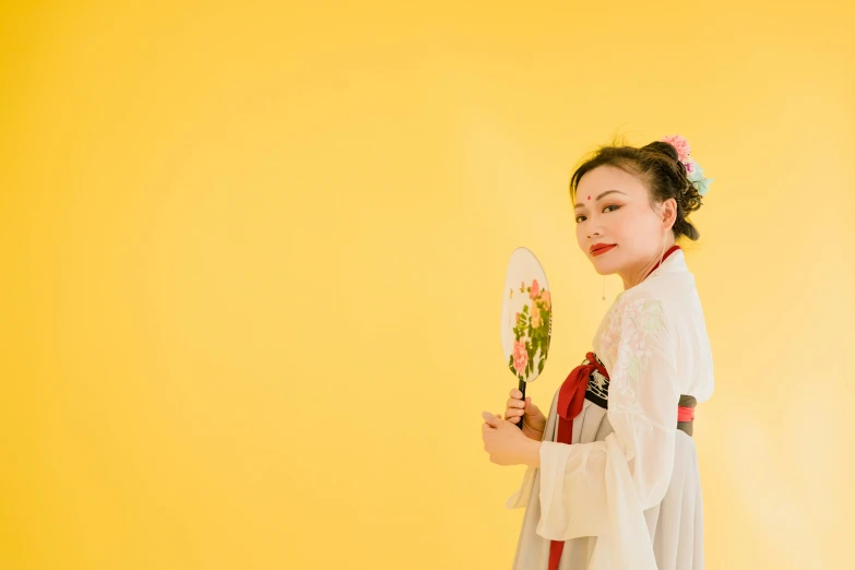 a woman in a white dress holding a fan, inspired by Tang Di, pexels contest winner, mingei, wearing yellow floral blouse, holding sabre, 15081959 21121991 01012000 4k, delightful